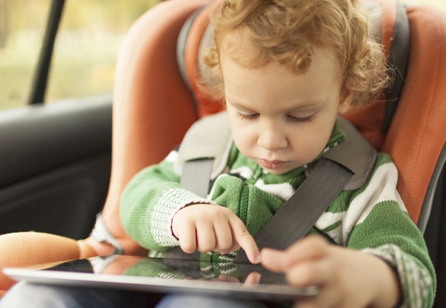 A curios little boy plays with a tablet