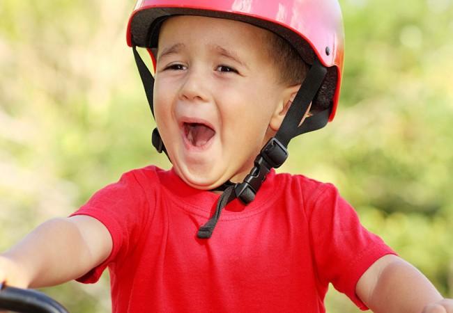 A nervous but excited little boy riding a bike