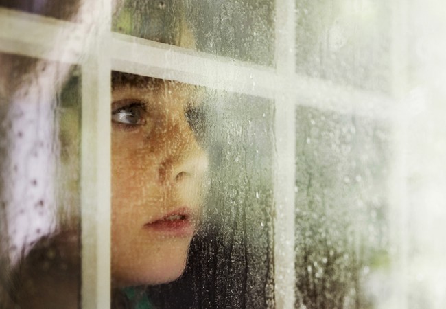 A little girl gazes out the window during heavy rains