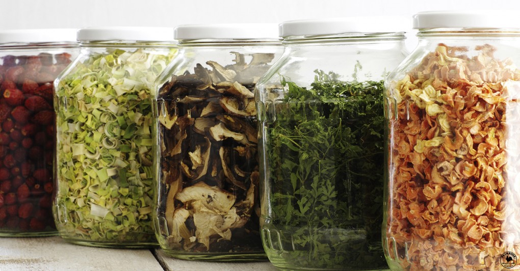 Berries, vegetables, mushrooms and herbs, neatly placed in separate jars