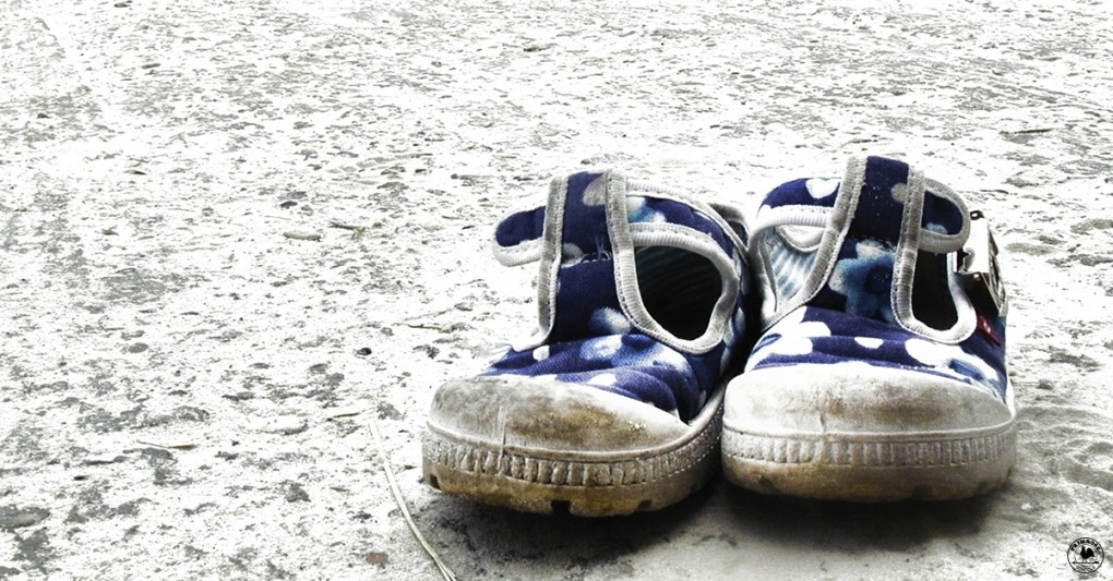 A pair of grimy toddler shoes, depicting the threat that was posed to children during hurricane Katrina