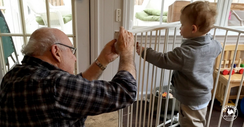 Little boy helps his grandfather assemble a crib