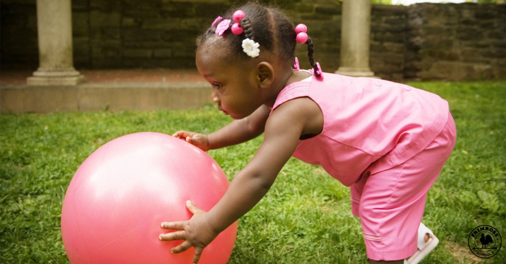 Little girl plays with a balance ball