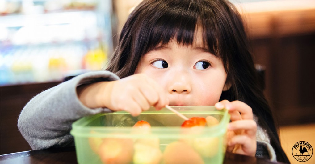 A picky young girl looks away from her bowl of fruit