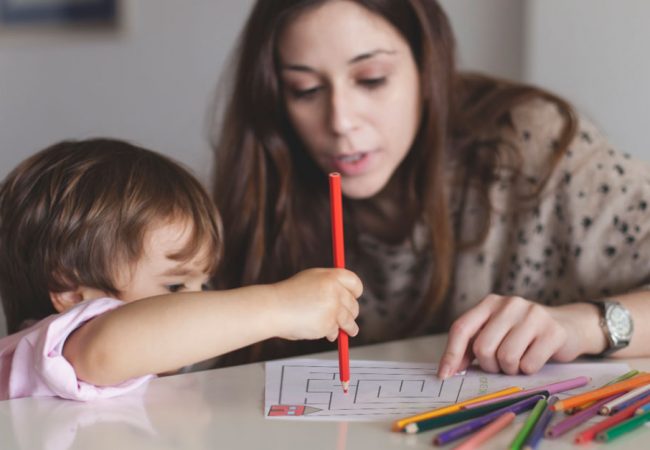 Mom helps her young child complete a printable safety activity