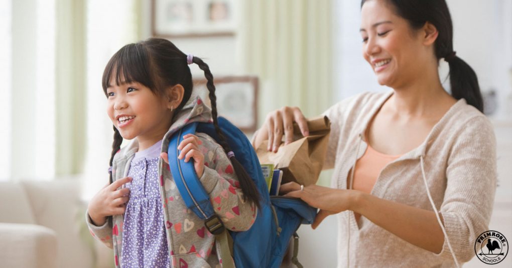Mother packs her daughter's lunch as she prepares to leave for school