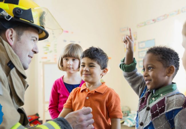 A firefighter interacts with a group of students