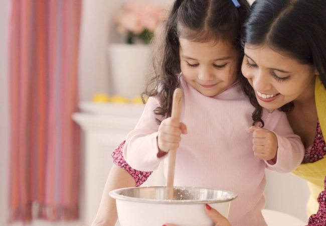 Little girl helps her mother in mixing ingredients for a thanksgiving dish