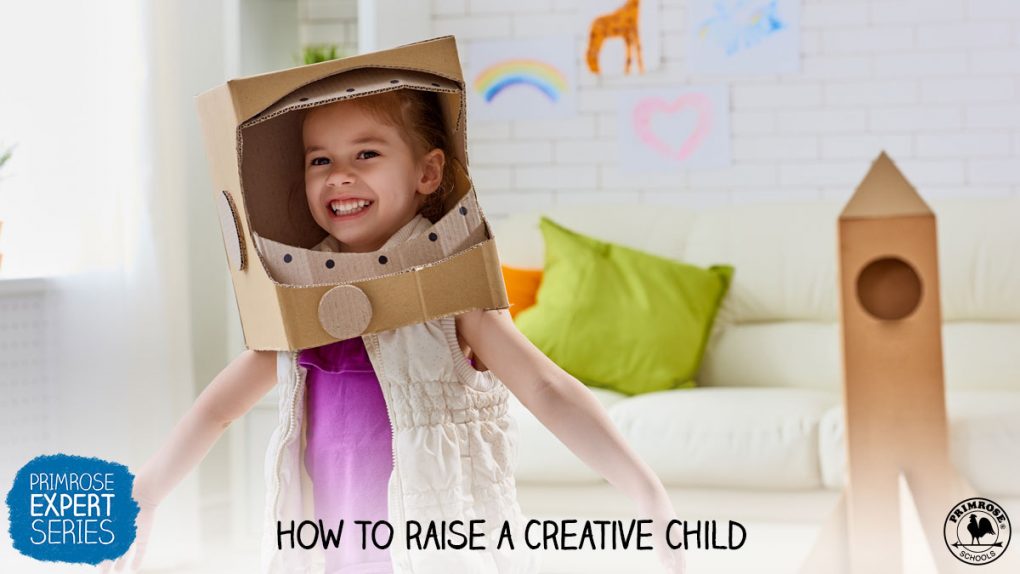 A happy young girl wearing an astronaut helmet made from cardboard