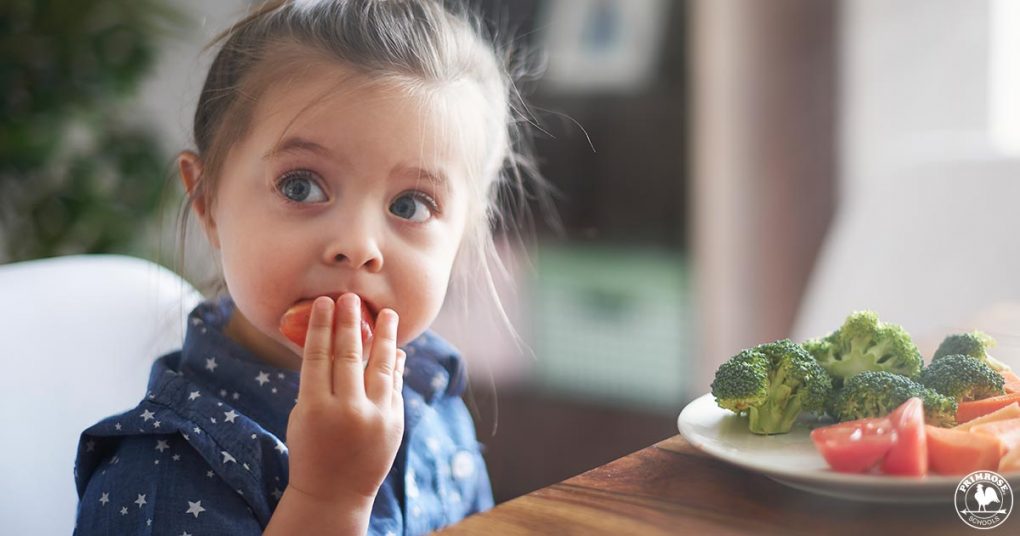 Young girl eating healthy vegetables at the dinner table