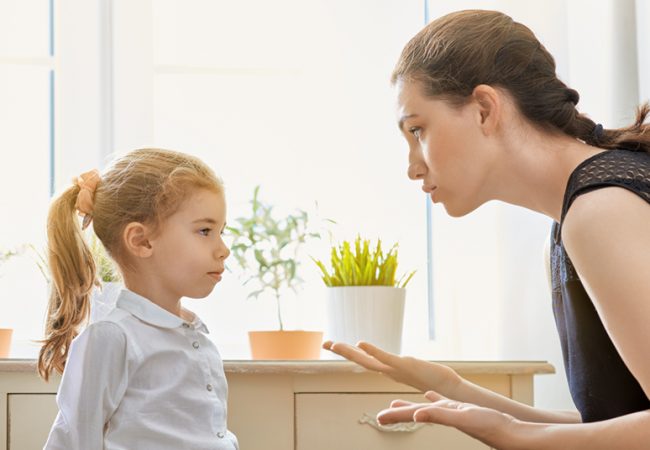 Mom talks to upset young child using positive parenting techniques.