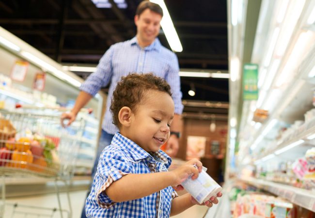 A preschooler enjoys easy activities while grocery shopping with his father.