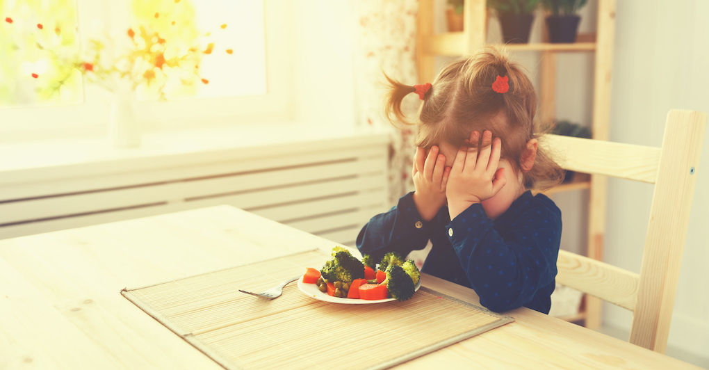 A young picky eater refuses to eat her vegetables