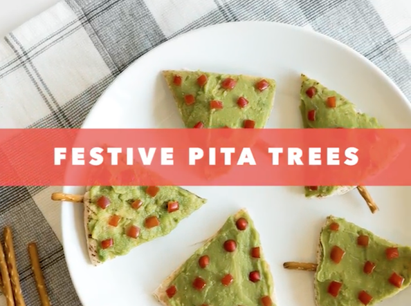 White plate with pita bread cut into triangles, topped with guacamole and tomatoes to look like a Christmas tree.