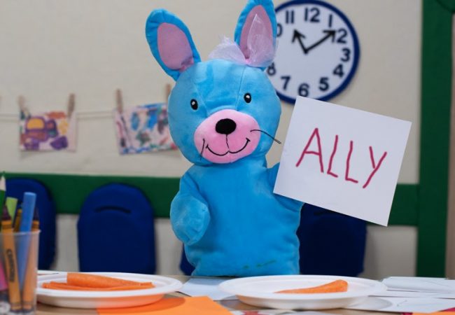 Ally the Bunny holding up a card with her name on it