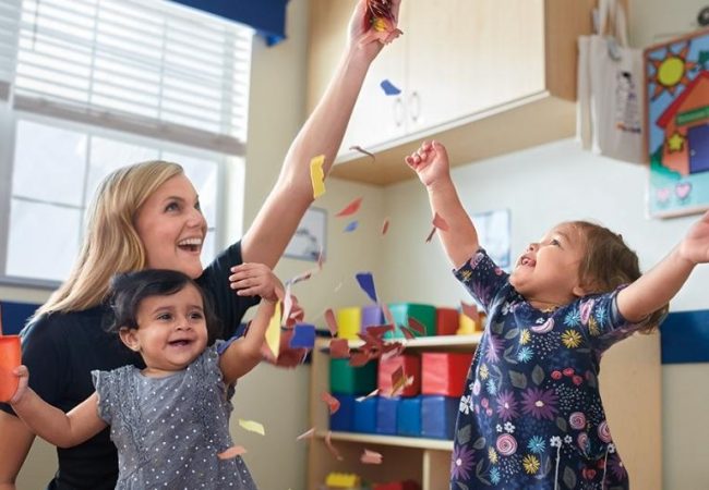 happy teacher and toddlers in classroom