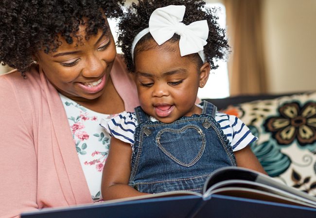 caregiver and little girl reading books