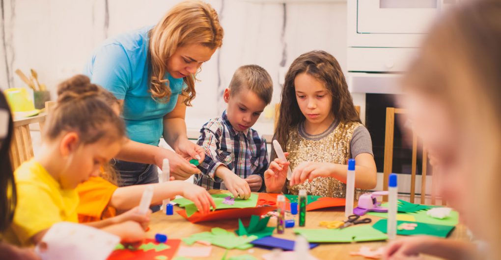 Parent helping children with arts and craft activity