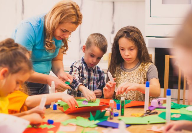 Parent helping children with arts and craft activity